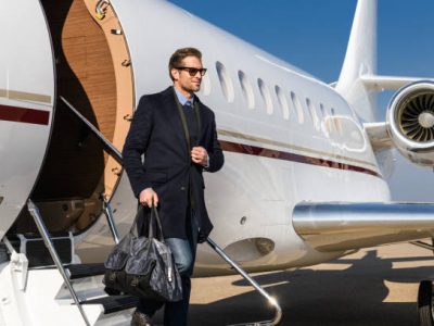 Man with a bag leaving the private jet airplane upon arrival.